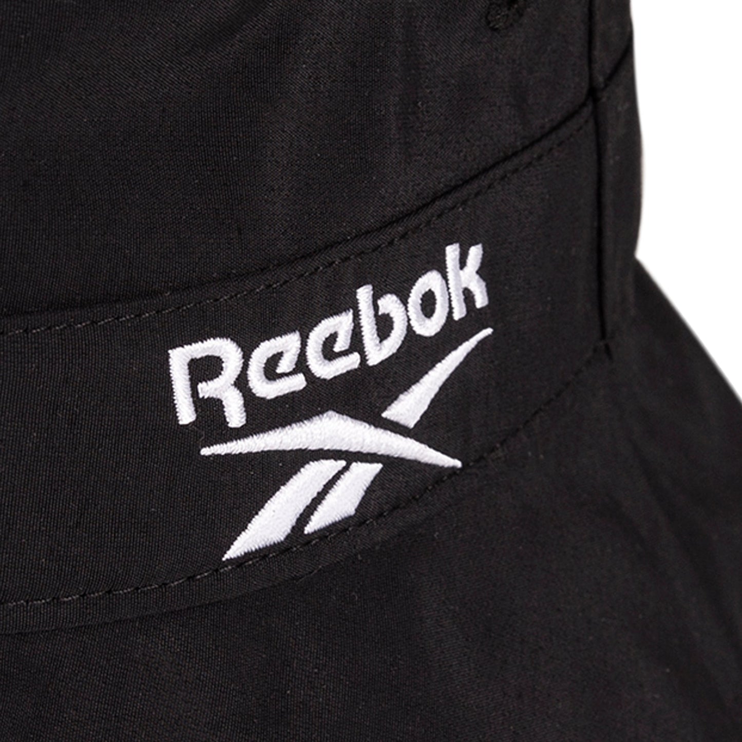 Close-up of a black Reebok Bucket Hat with the white embroidered Reebok logo and text.