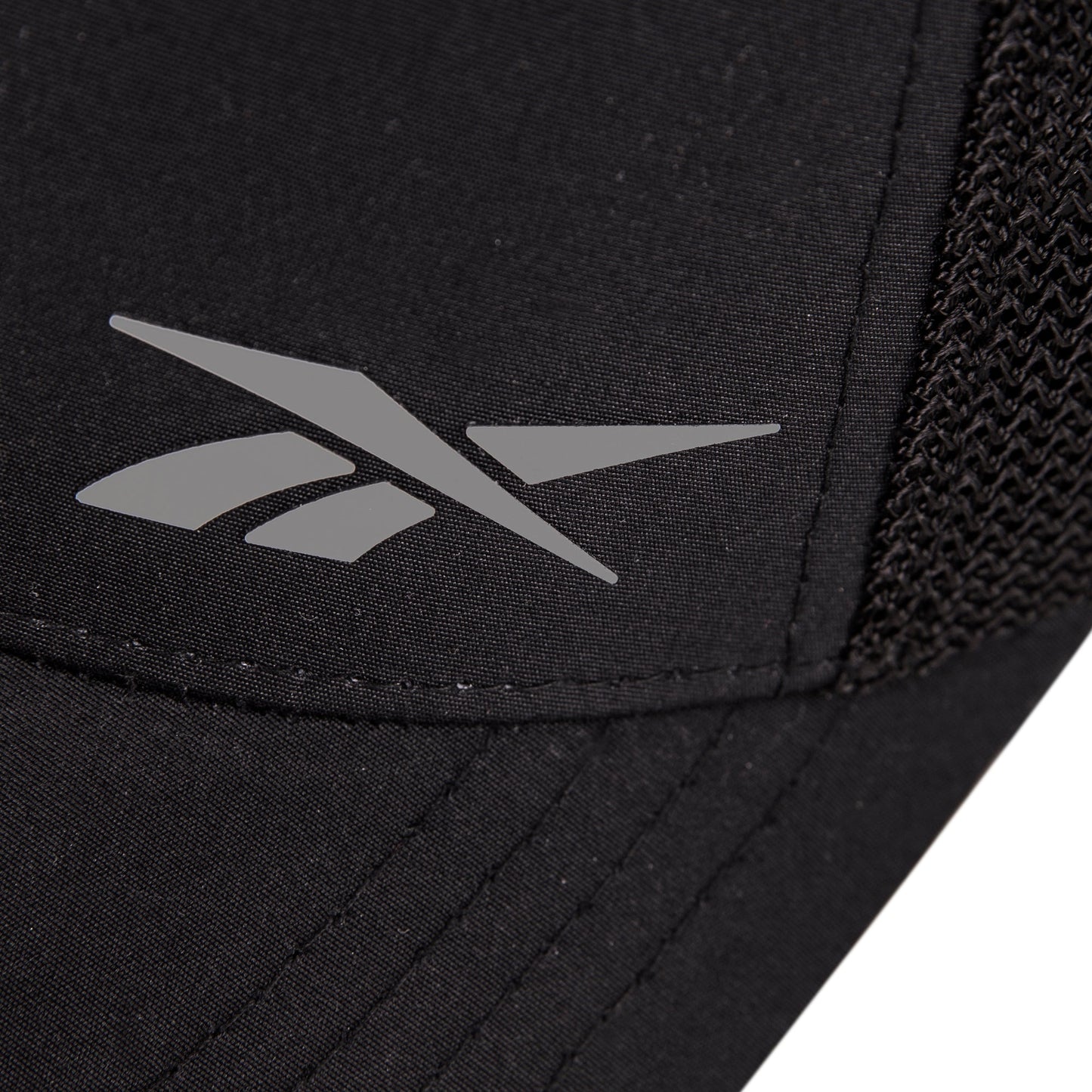Close-up of the Reebok Athletic Cap in black, featuring a silver logo and right-side mesh detailing for comfort. Made from recycled polyester.