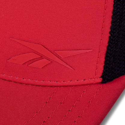 Close-up of the red Reebok Athlete Cap featuring an embossed Reebok logo on the front, black mesh fabric on the side, and detailed stitching along the seam.