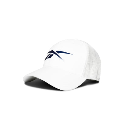 The Reebok Elite Cap is white with a curved brim, stretch mesh back, and a dark blue abstract logo on the front. This performance fitted hat sits on a white background with a soft shadow.