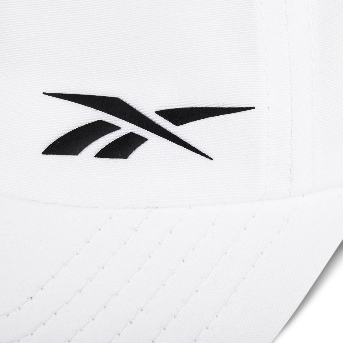 Close-up of the Reebok Flow Cap in white, crafted from recycled polyester with a black Reebok logo on the front, curved brim with visible stitching, and a moisture-wicking sweatband for added comfort.