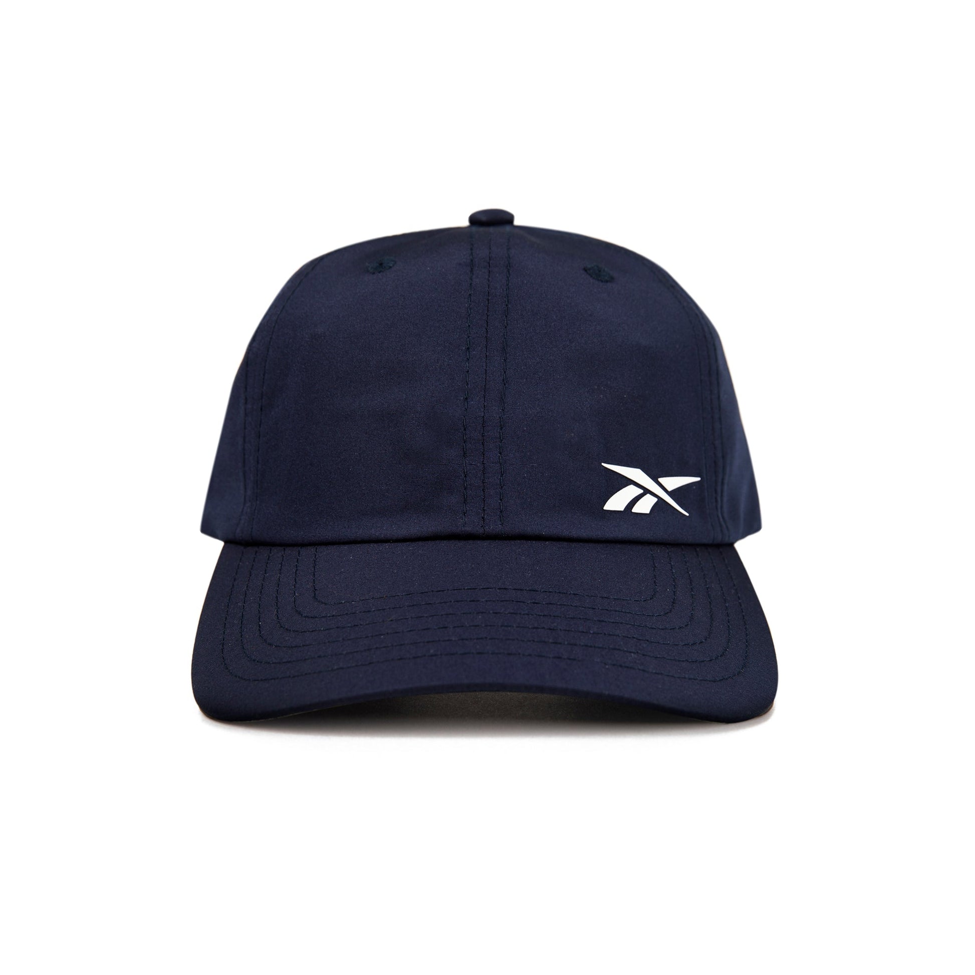 A front view of the Reebok Flow Cap in navy blue, featuring a small white Reebok logo on the left crown and a moisture-wicking sweatband for comfort.