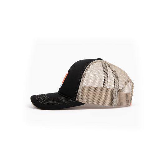 The Reebok Vintage Trucker Cap features a black front and brim, beige mesh back, and snapback closure. Shown side view, it displays a small front patch that highlights Reebok's athletic heritage.