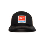 The Reebok Vintage Trucker Cap is black with white stitching, mesh back, a red and white Reebok logo patch on the front, and an adjustable snapback closure for classic athletic heritage style.