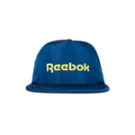 The Reebok Flat Brim Running Cap is a blue, lightweight hat with moisture-wicking fabric, featuring a flat brim and bold yellow Reebok logo on the front, shown against a white background.