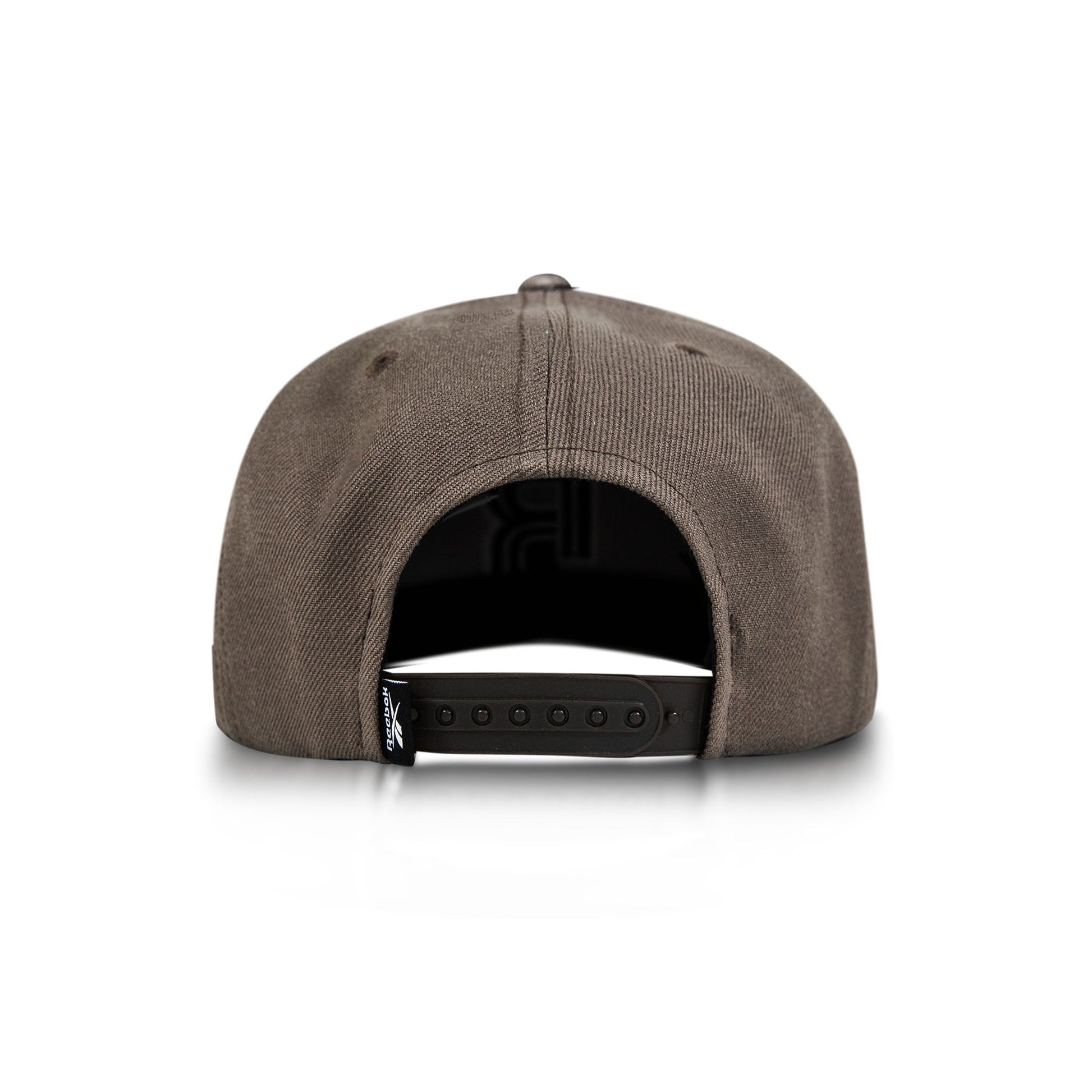 A brown Reebok Identity Drop R Cap is shown from the back on a white background, highlighting its adjustable snapback closure and a small black tag on the left side.