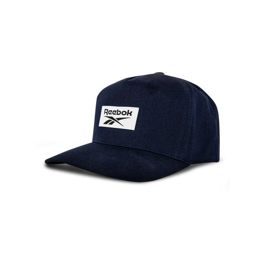 The Reebok Classic 5 Cap is a navy blue athletic cap with a curved brim and a white rectangular front patch featuring the Reebok logo and text, shown against a white background.