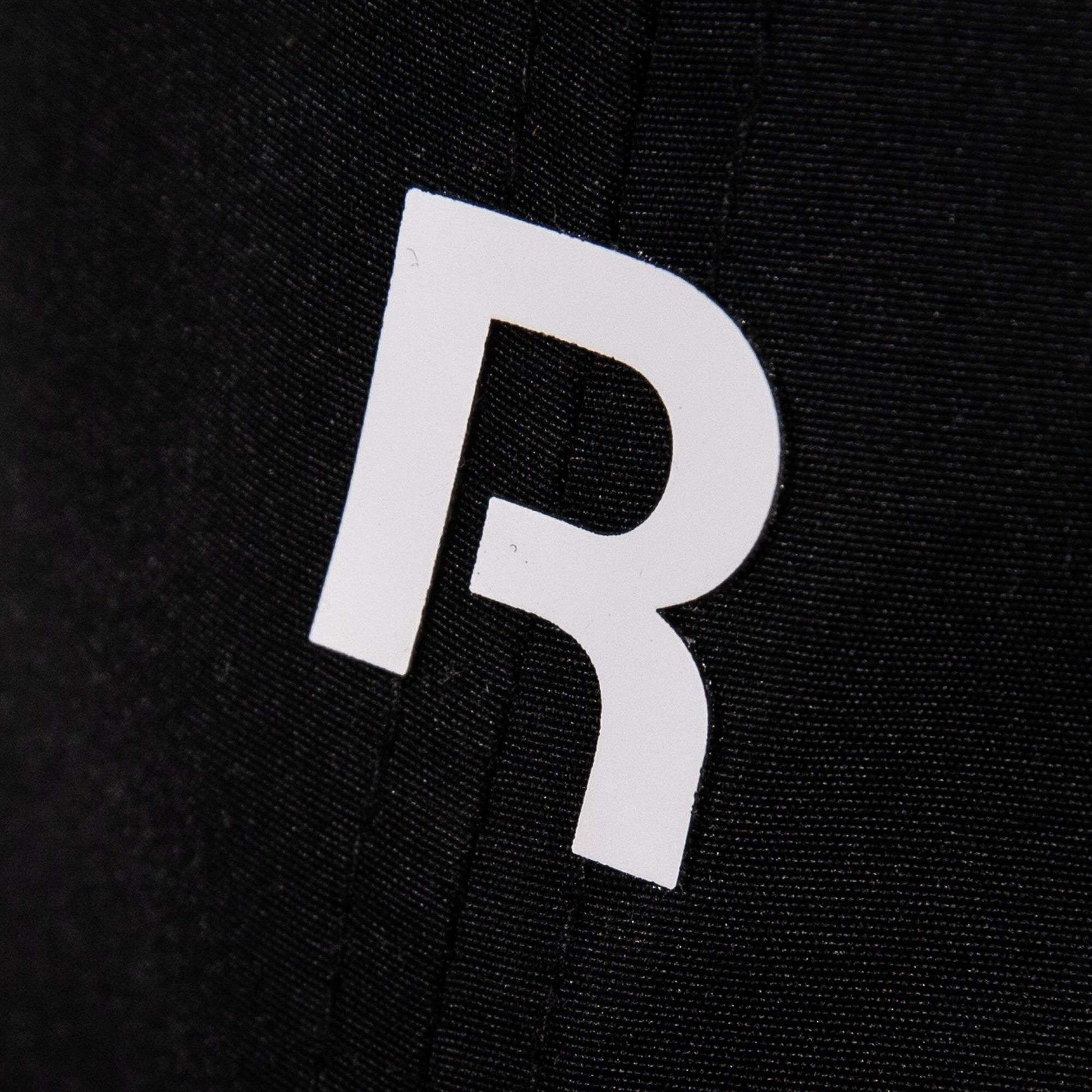 The Reebok Drop R Court Cap features a white, stylized letter R printed on black fabric, accented by visible vertical stitching.