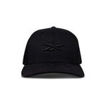Front view of the Reebok Embroidered Vector Trucker Cap in black, featuring a curved brim, mesh back, and embroidered black Reebok logo on the front panel. Shown against a plain white background.