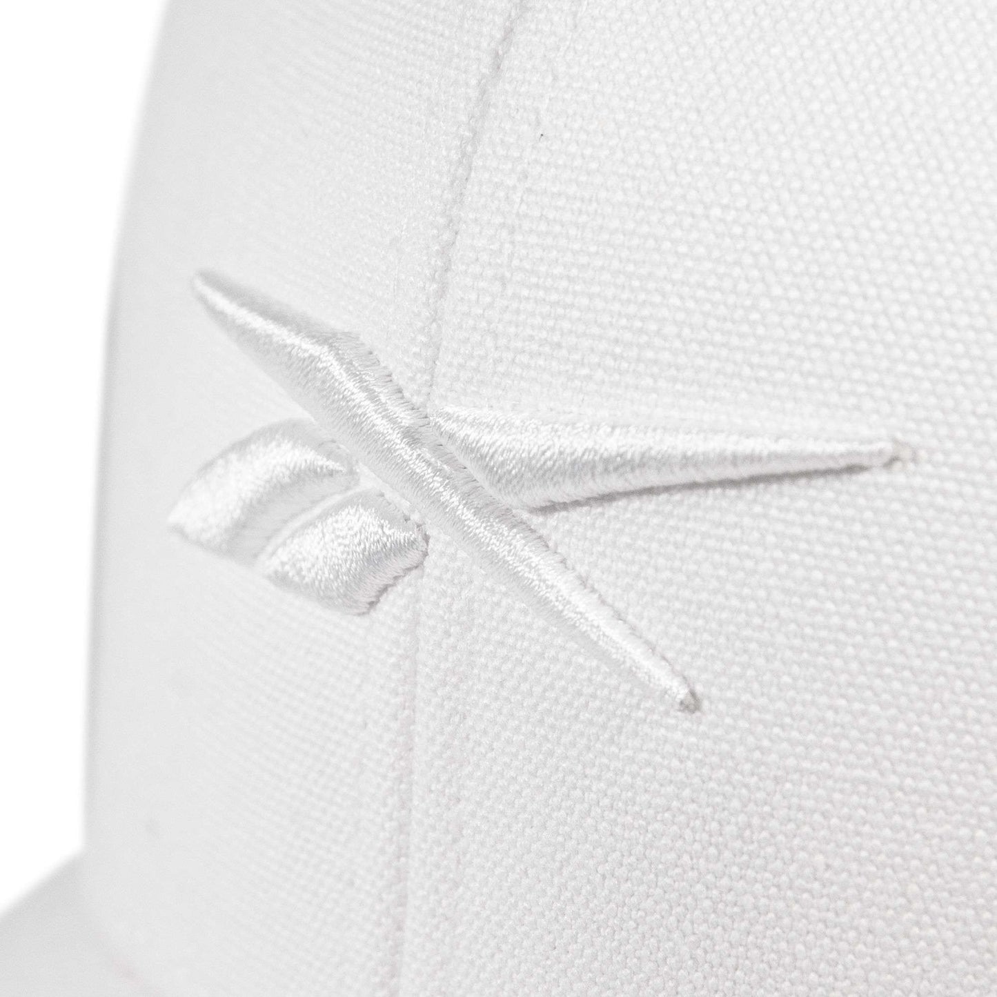 Close-up of the Embroidered Vector Trucker Cap by Reebok, showing a white fabric surface with the Reebok logo stitched in white thread.