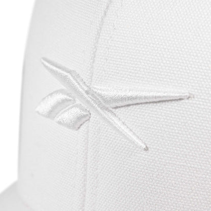 Close-up of the Embroidered Vector Trucker Cap by Reebok, showing a white fabric surface with the Reebok logo stitched in white thread.