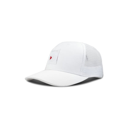 The Reebok Woven Patch Vector Trucker Cap is a white hat with mesh back panels and a front rectangular patch, shown on a plain white background.