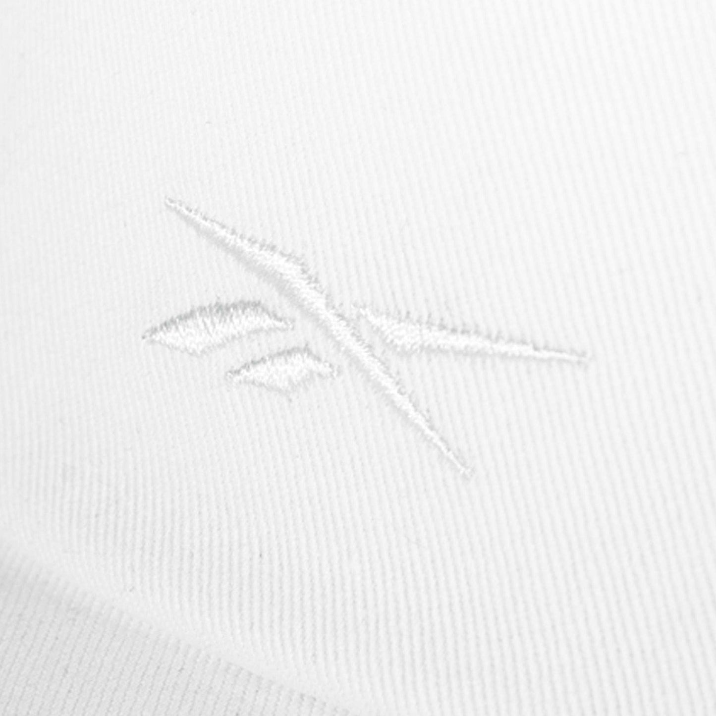 Close-up of a white cotton twill Reebok Logo S-Vector Cap, featuring a subtle, embroidered Reebok logo in matching white thread for a minimalist, textured look.
