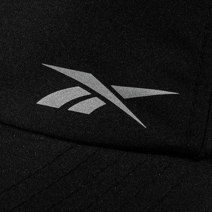 Close-up of a black Reebok Flow Piped Cap with a silver logo on the front and a moisture-wicking sweatband for all-day comfort.