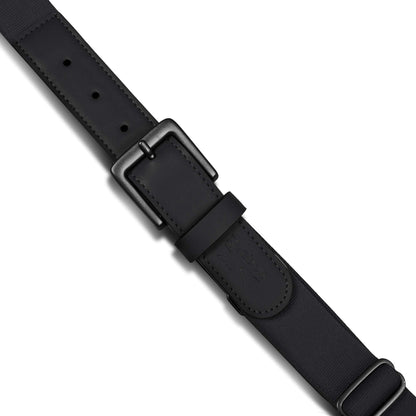 A close-up of the Reebok Youth Baseball Belt, featuring a matte black rectangular buckle, leather detailing with stitched edges, and a stretch elastic adjustable strap with multiple holes for comfort.