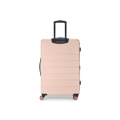 A large, hard-shell suitcase in a light pink color with four wheels and a black telescopic handle, standing upright on a white background.