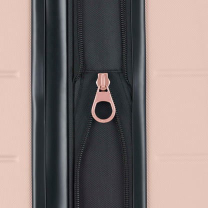 Close-up of a black zipper with a pink pull tab on a textured pink suitcase. The zipper is centered vertically between two suitcase panels.