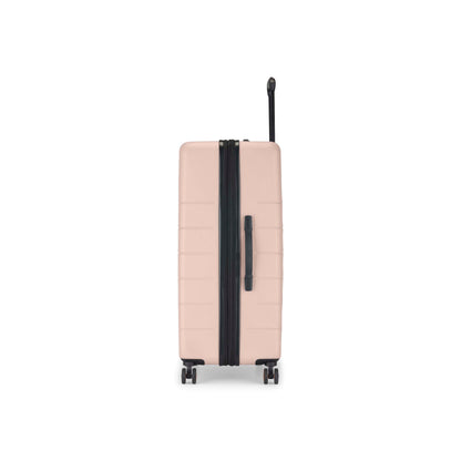 A beige hard-shell suitcase stands upright on four wheels, viewed from the side. It has a black zipper, black side handle, and an extended black telescoping handle against a white background.