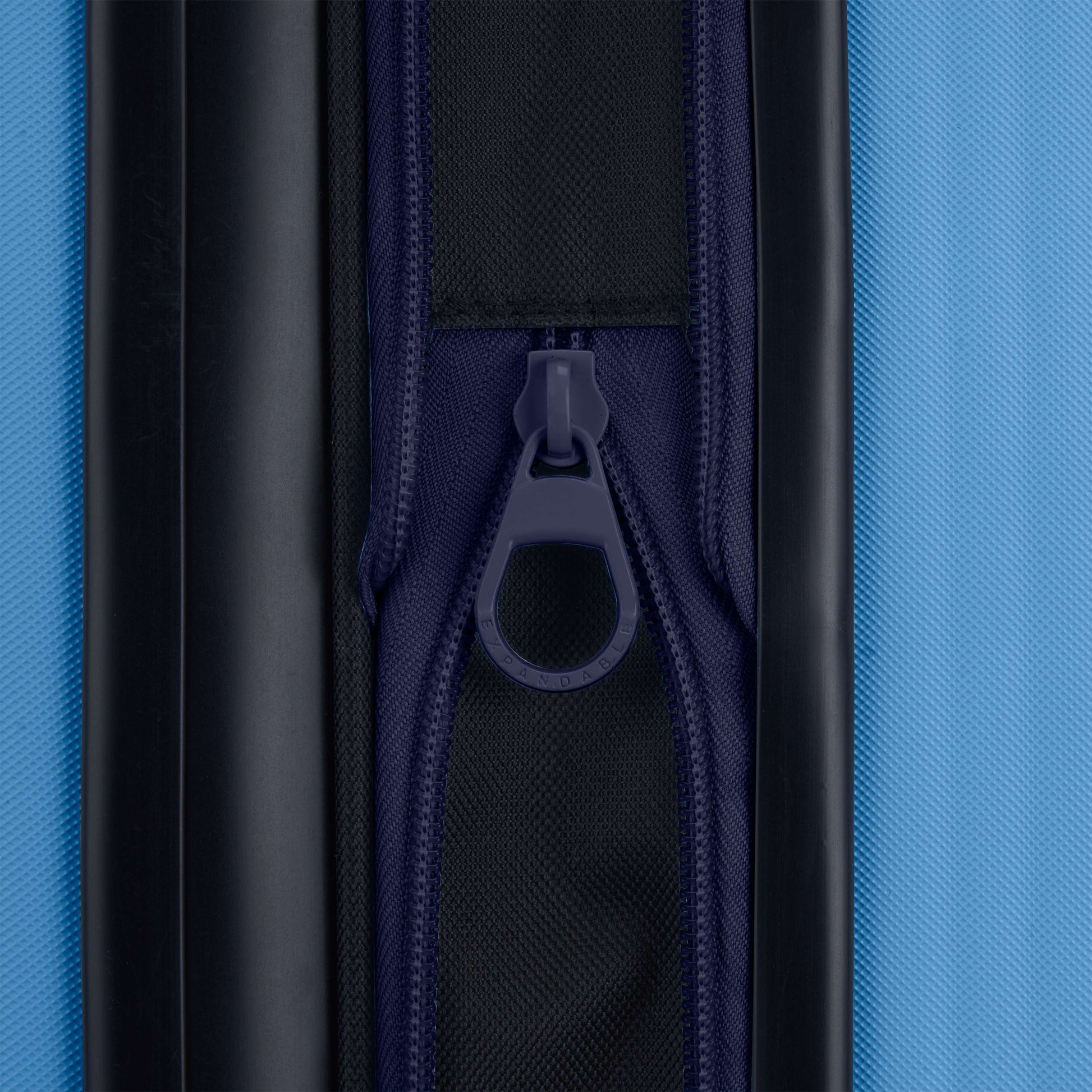 Close-up of the dark blue zipper on the Reebok Action Duo 2 Piece Luggage Set, showing a textured black and blue fabric and centered zipper pull.