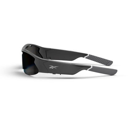 Reebok Octane Smart Audio Sunglasses in black and gray feature thick, angular frames, polarized lenses, and the Reebok logo on the side. Shown folded and resting on a white surface.