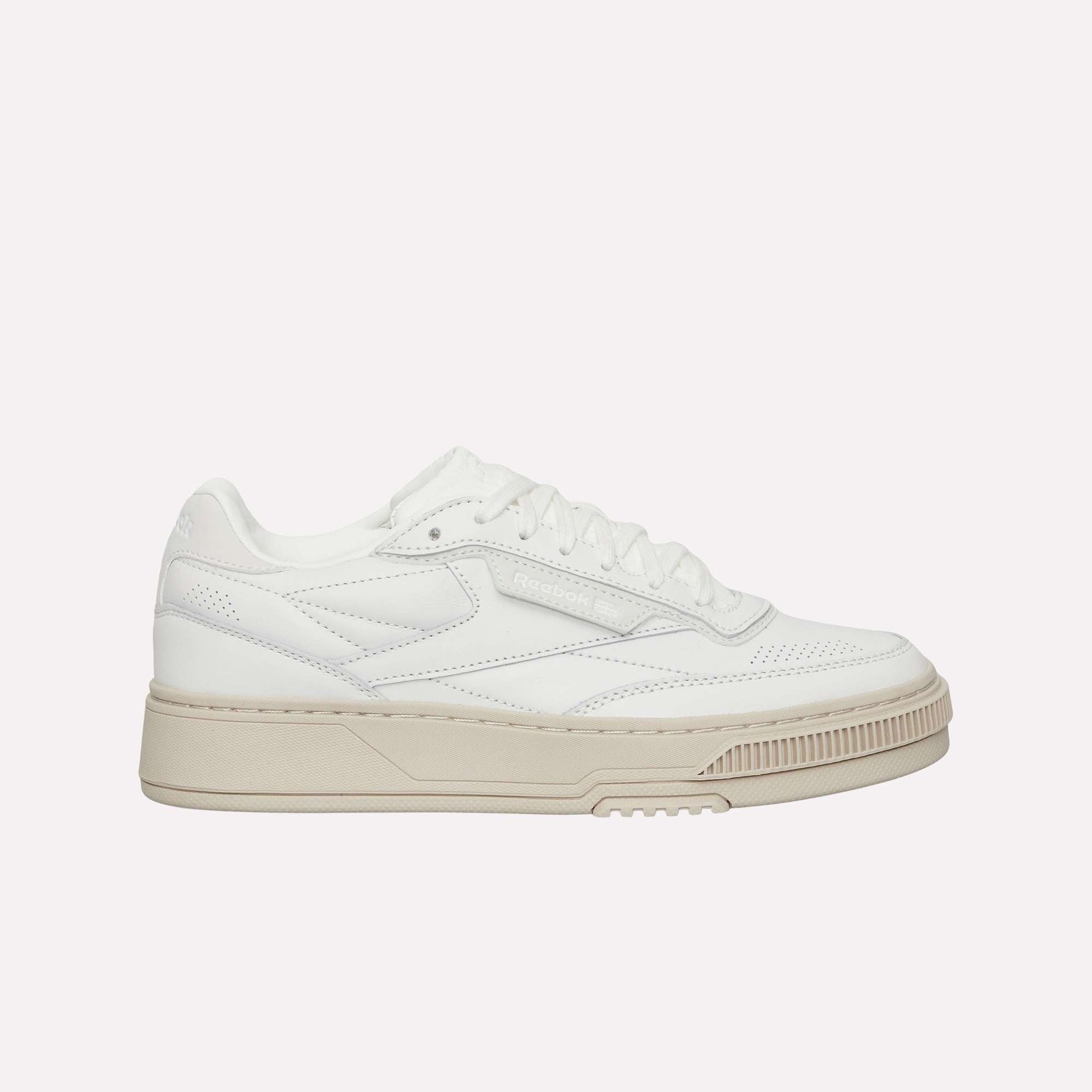 The Reebok Club C LTD Shoes are white low-top sneakers with a beige sole, perforated details, and white laces, shown in a side profile view—a timeless lifestyle classic inspired by tennis heritage.