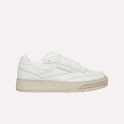 The Reebok Club C LTD Shoes are white low-top sneakers with a beige sole, perforated details, and white laces, shown in a side profile view—a timeless lifestyle classic inspired by tennis heritage.