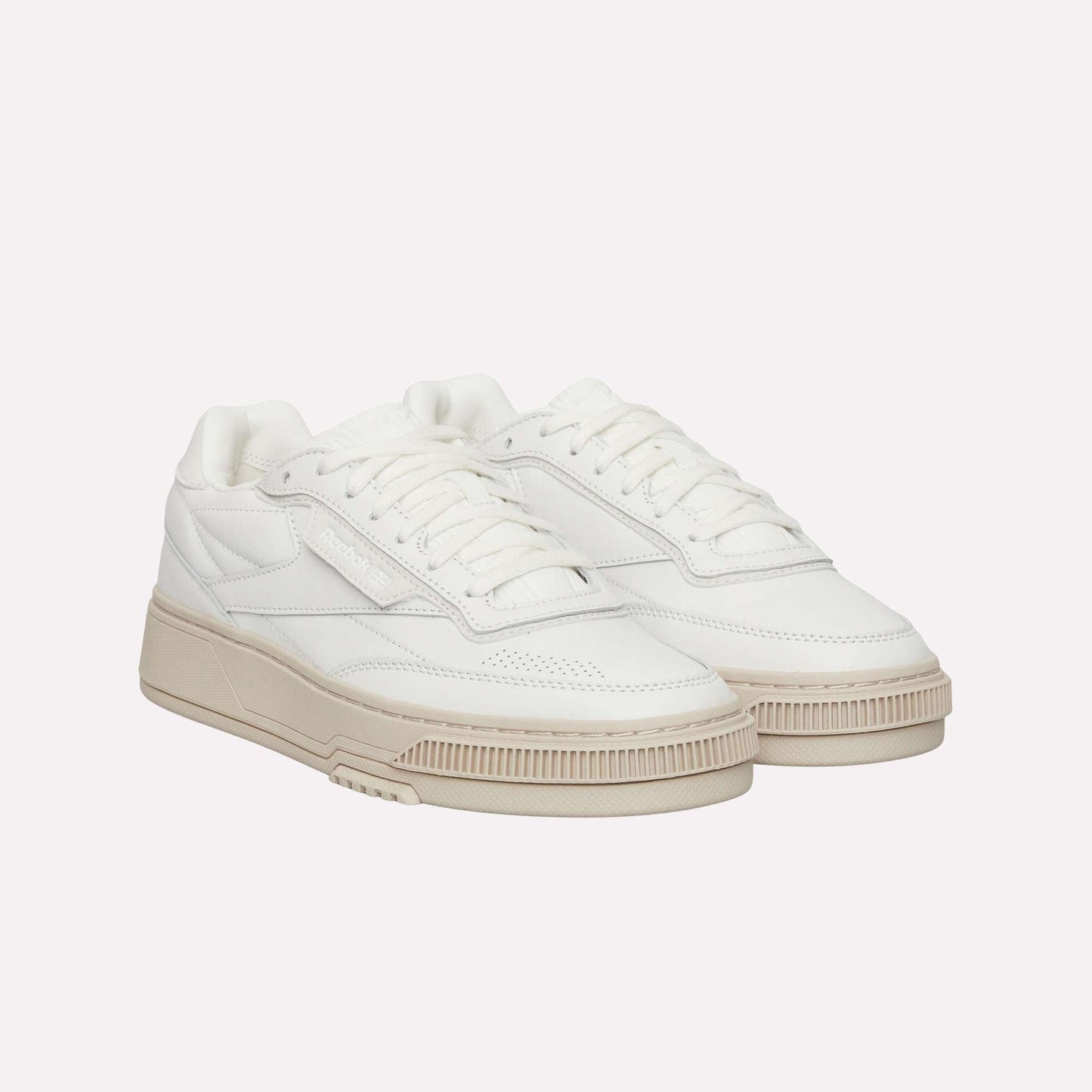 The Reebok Club C LTD Shoes feature a clean, minimalist white low-top design with beige chunky soles, white laces, and subtle stitching details—making them a timeless lifestyle classic.