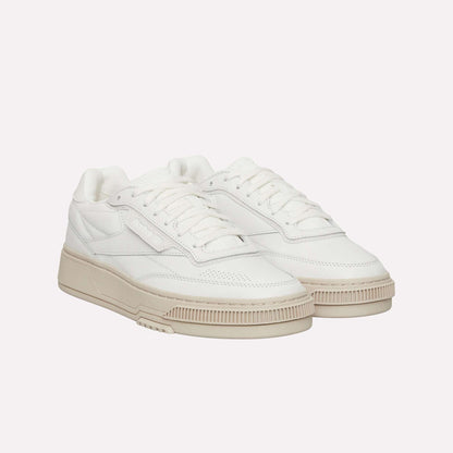 The Reebok Club C LTD Shoes feature a clean, minimalist white low-top design with beige chunky soles, white laces, and subtle stitching details—making them a timeless lifestyle classic.