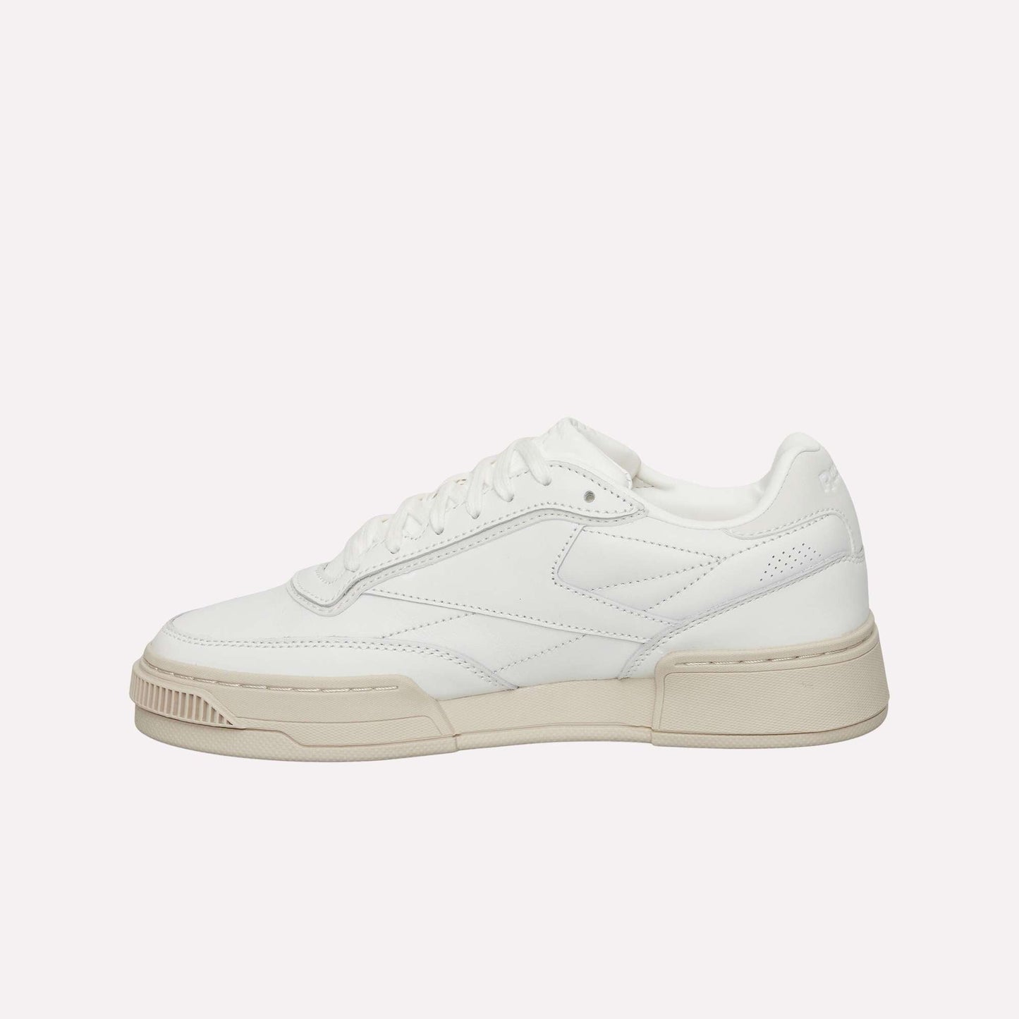 The Reebok Club C LTD Shoes are white low-top sneakers with a beige sole, white laces, and subtle stitching details—an iconic lifestyle classic inspired by the original Club C tennis shoe. Displayed on a plain white background.