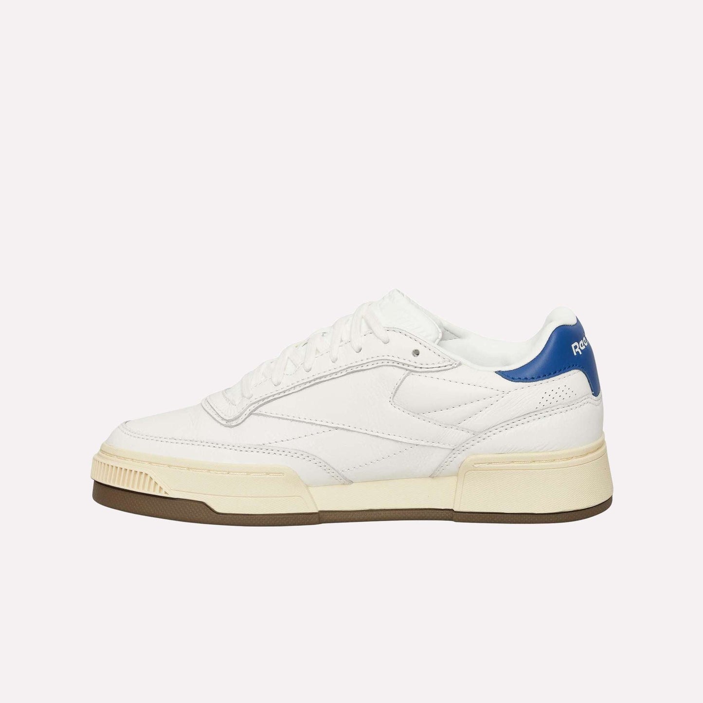 The Reebok Club C LTD Shoes feature white leather, a cream sole, brown outsole, blue heel accent, white laces, and minimalist Club C branding on the heel tab.