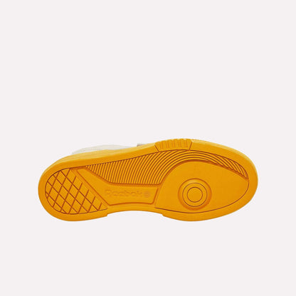 The image shows the yellow sole of Reebok Club C LTD Shoes from below, featuring textured patterns, circular and linear tread designs, and the Reebok logo—highlighting its classic tennis heritage.