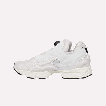 The Reebok Instapump Sliver Shoes feature a modern white and light gray design with black accents, a chunky sole, futuristic style, and Hexalite cushioning. Displayed on a light blue background.