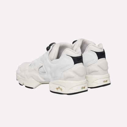 The Reebok Instapump Sliver Shoes, white with chunky soles, black heel accents, and cutout details featuring Hexalite cushioning, are shown from the back on a light blue background.
