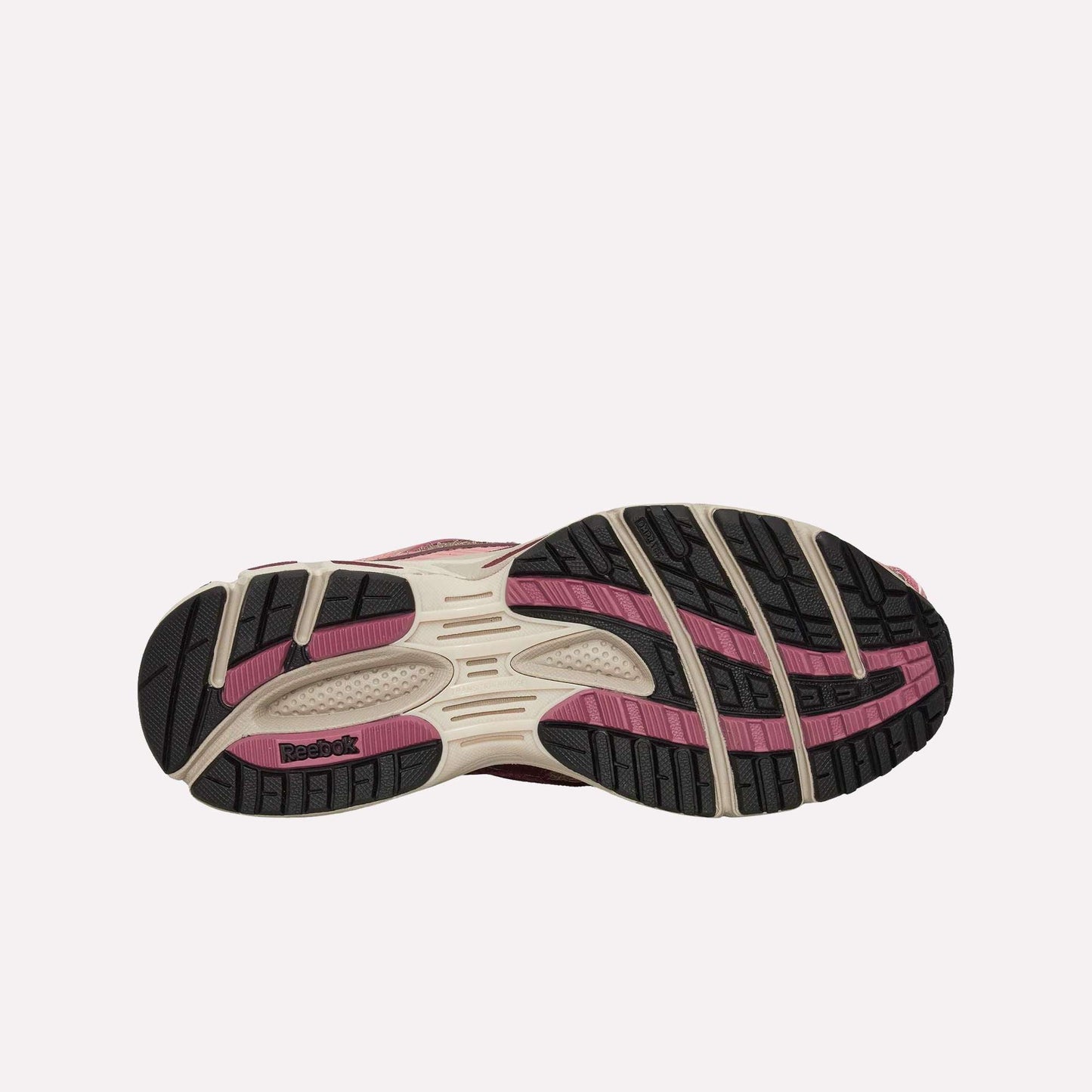 The image displays the outsole of the Reebok Premier Road Ultra Shoes, showcasing a treaded black sole with beige and pink accents, the Reebok logo by the heel, traction grooves, and cushioning from a dual-density midsole.