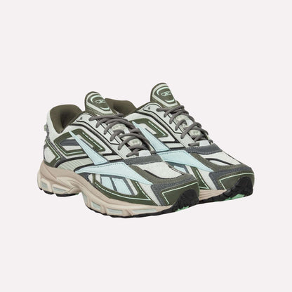 Reebok Premier Road Ultra Shoes with olive green, grey, white, and light blue panels and thick dual-density midsoles are shown against a plain light blue background.