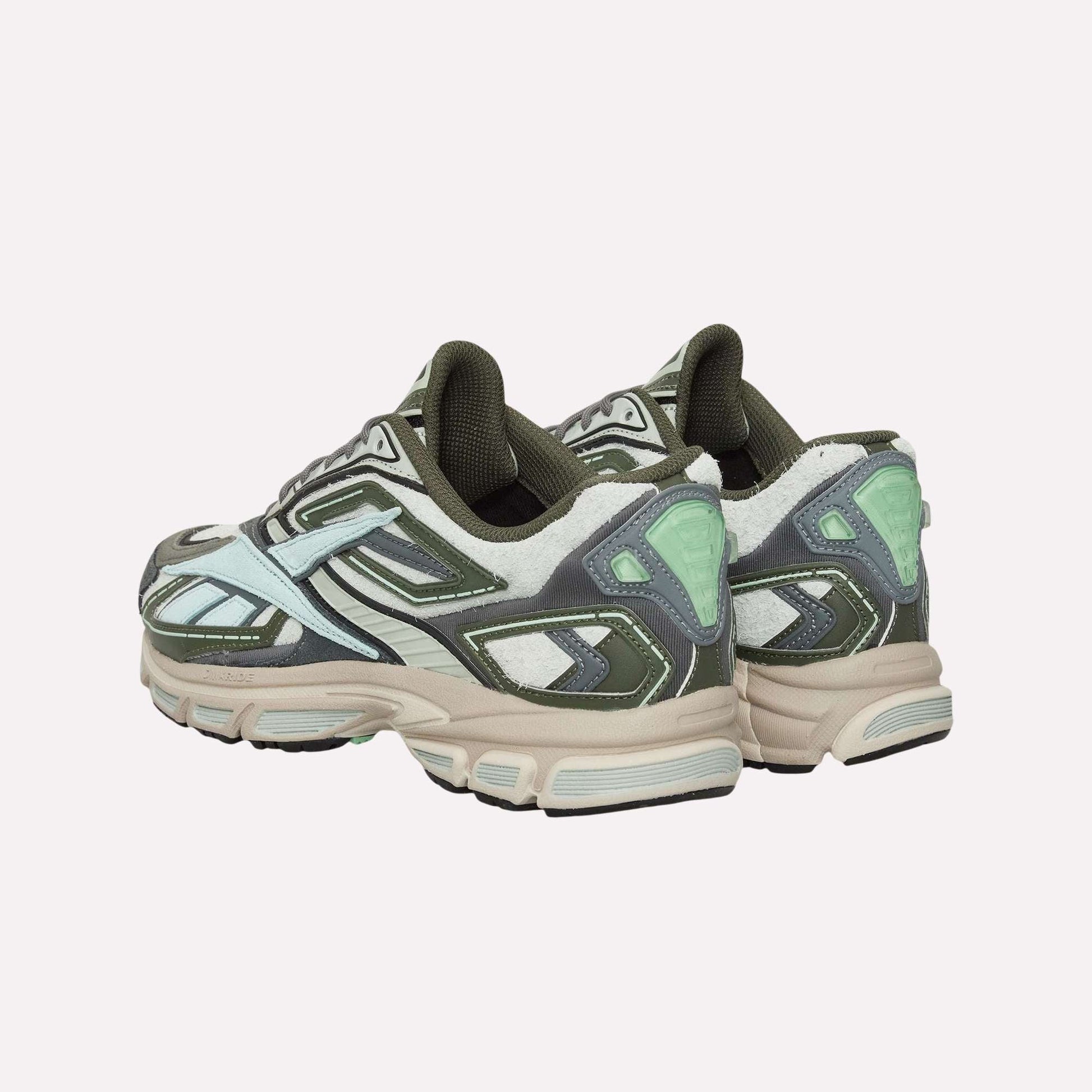 A pair of Reebok Premier Road Ultra Shoes in green, white, and mint with chunky beige soles and a dual-density midsole is displayed on a light blue background, shown from the back and side.
