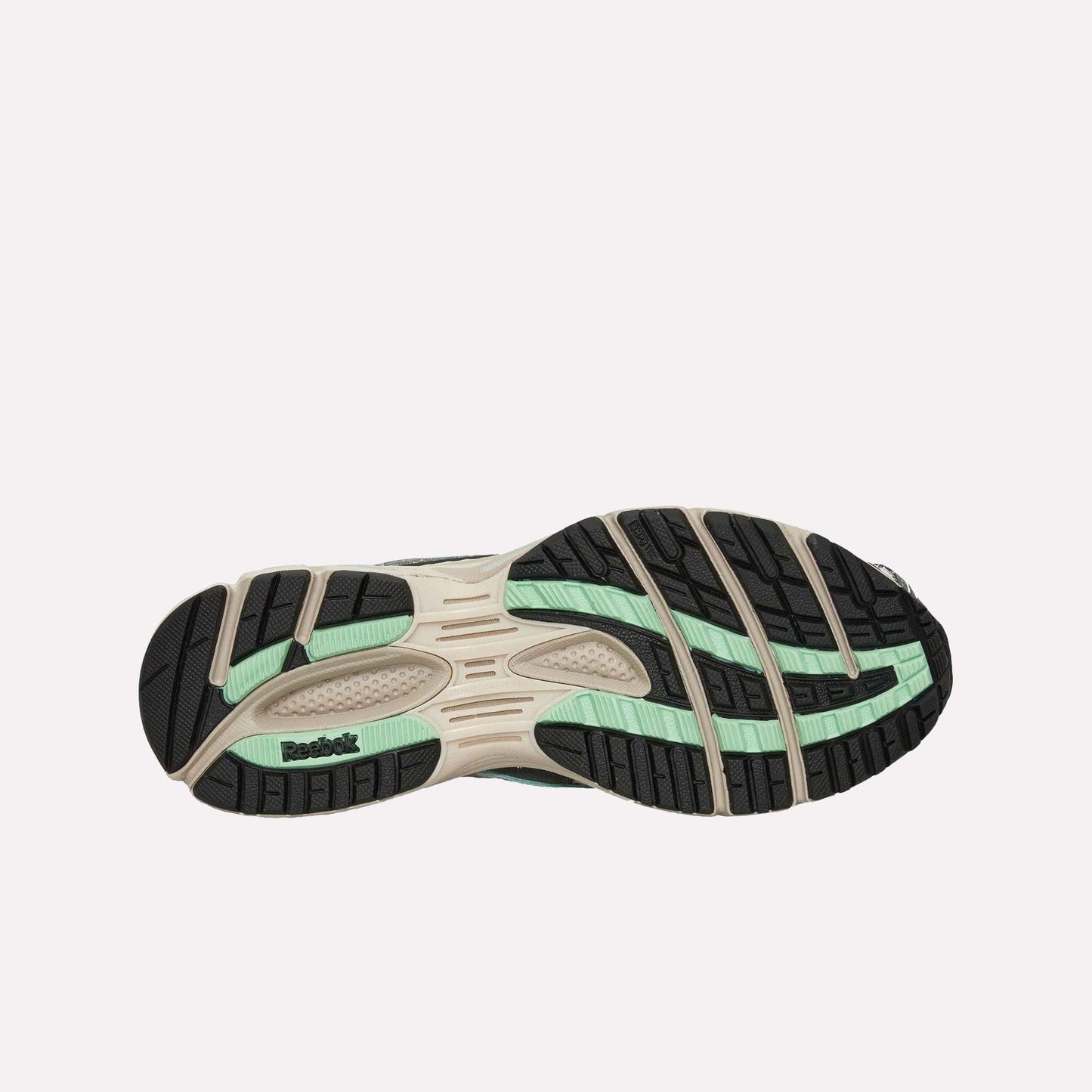 The image displays the sole of Reebok’s Premier Road Ultra Shoes, featuring black, beige, and mint green accents, multiple grooves, a dual-density midsole, textured patterns, and the Reebok logo on the heel against a light blue background.