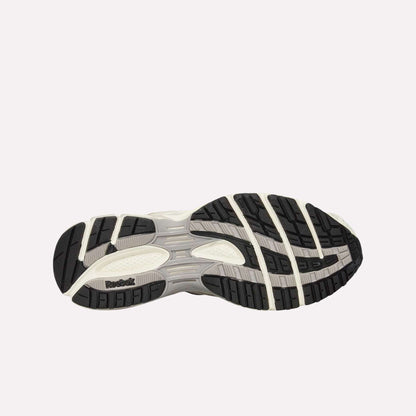 The image shows the sole of Reebok Premier Road Ultra Shoes, with a patterned tread in black, white, and gray, and the Reebok logo near the heel on a light blue background.