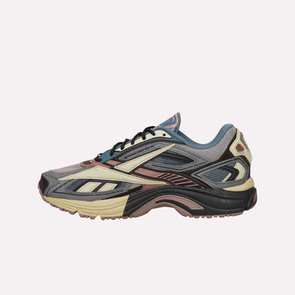 The Reebok Premier Road Ultra Shoes are multicolored running sneakers with blue, pink, cream, gray, and black mesh and synthetic overlays, a dual-density midsole, shown against a solid light blue background.