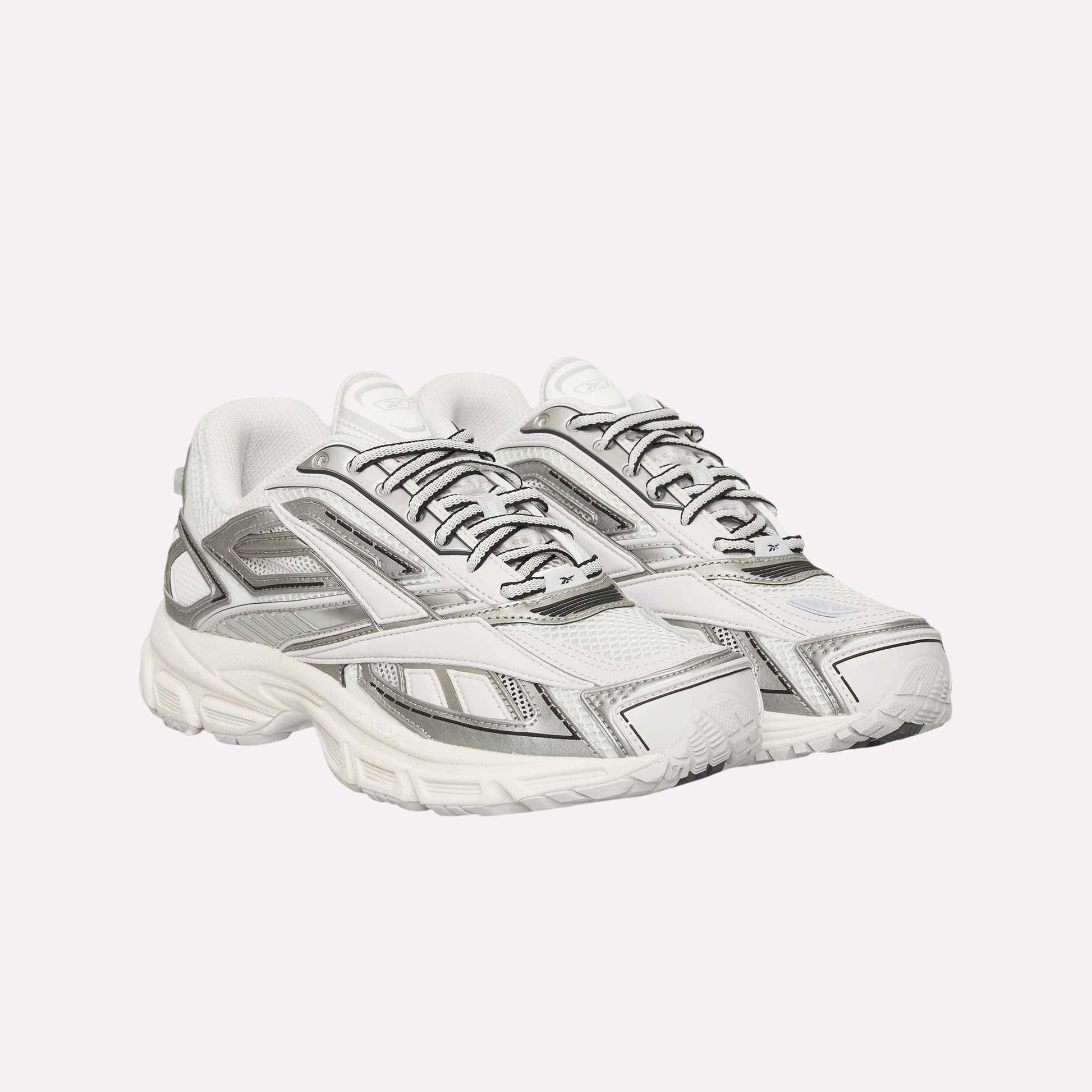 A pair of Reebok Premier Road Ultra Shoes in white with gray and silver accents, mesh panels, detailed stitching, and thick textured soles with a dual-density midsole, positioned side by side facing slightly right.