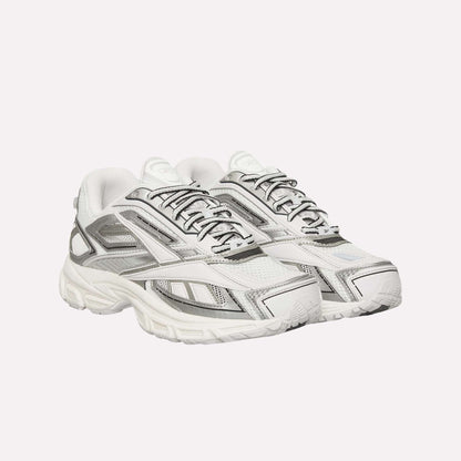 A pair of Reebok Premier Road Ultra Shoes in white with gray and silver accents, mesh panels, detailed stitching, and thick textured soles with a dual-density midsole, positioned side by side facing slightly right.