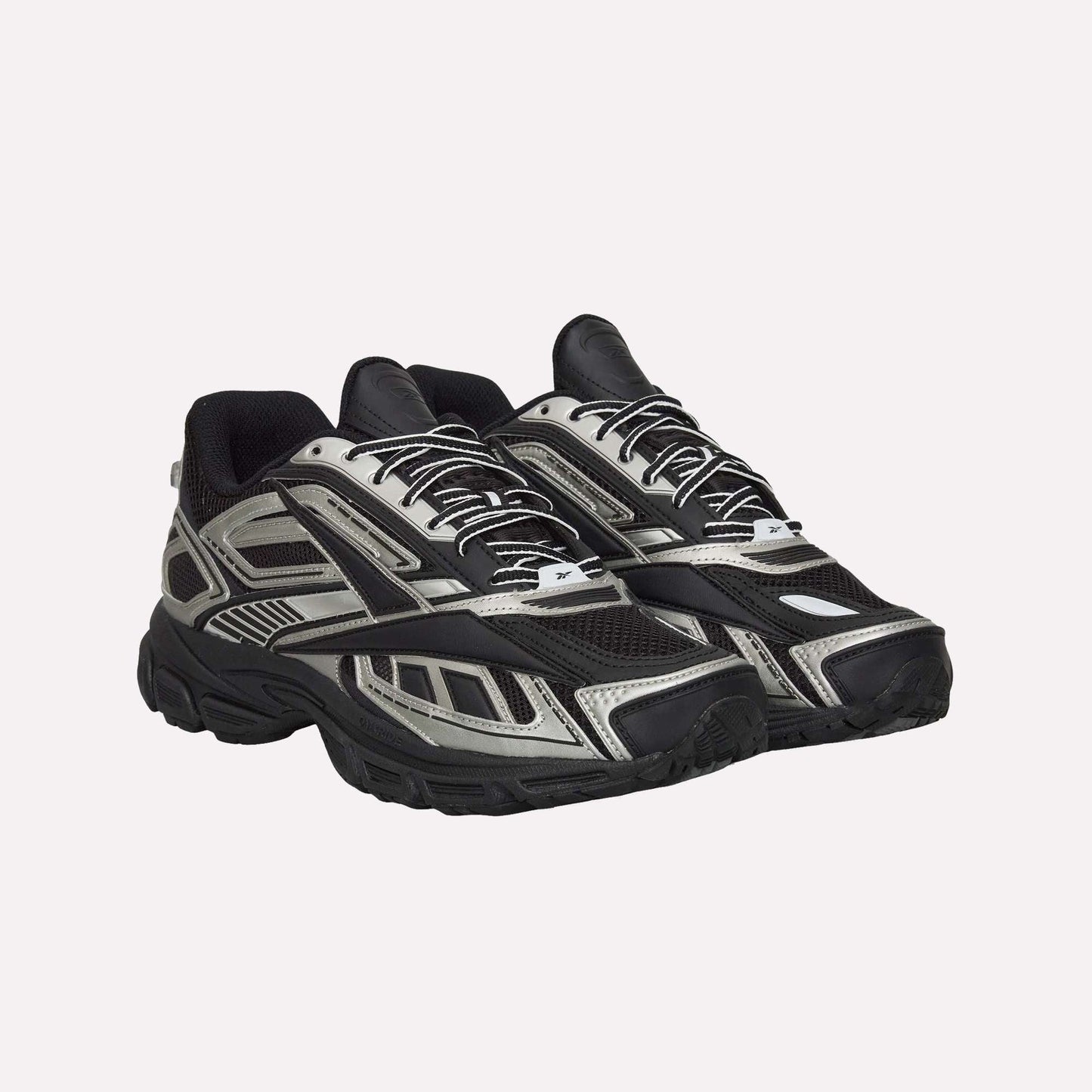 A pair of Reebok Premier Road Ultra Shoes in black and silver, featuring a chunky sole, mesh panels, dual-density midsole, and patterned overlays, displayed side by side angled slightly to the right.