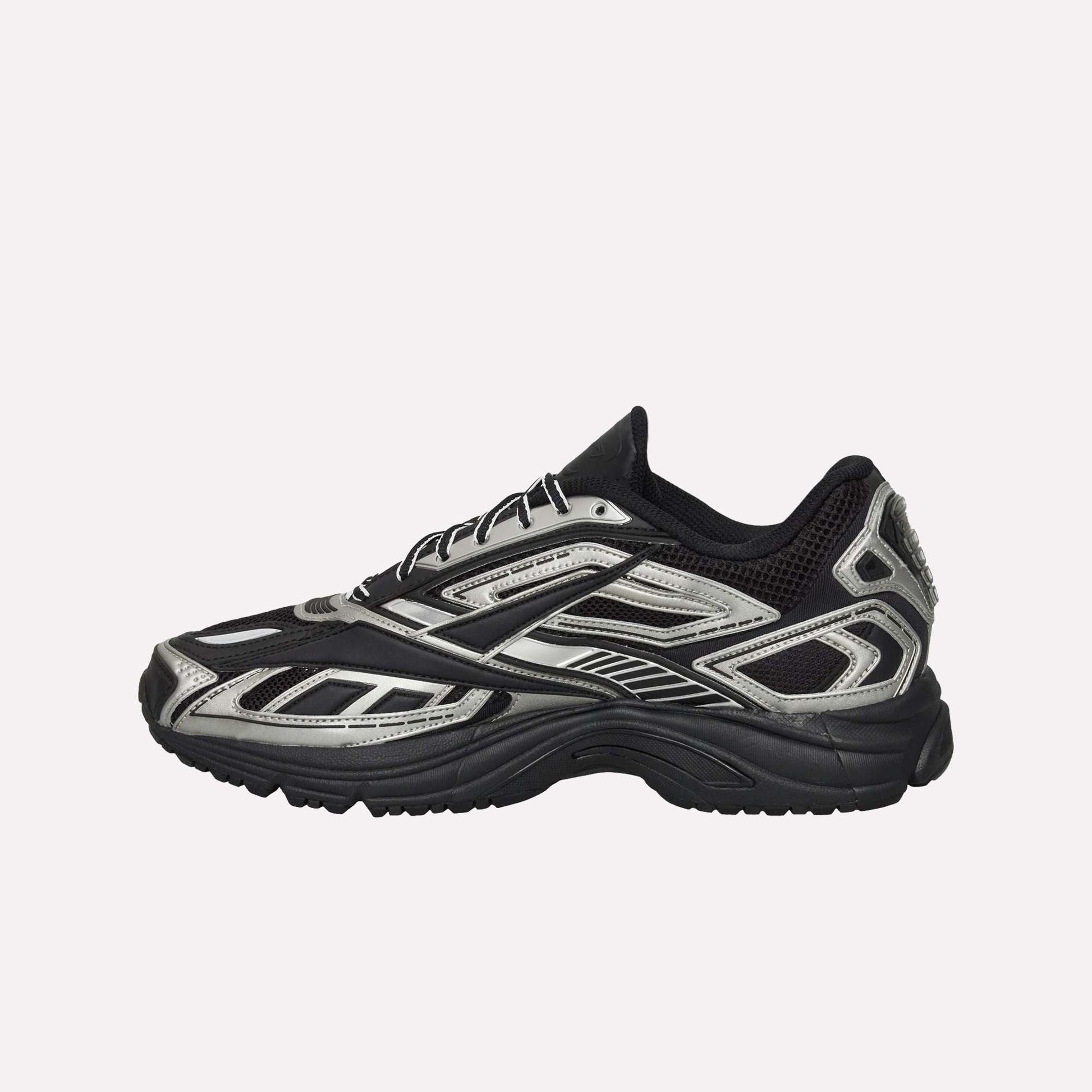 The Reebok Premier Road Ultra Shoes, shown from the side on a white background, feature a black mesh upper with silver accents, synthetic overlays in a layered design, and a chunky dual-density midsole for modern running style.