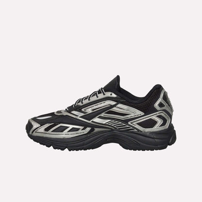 The Reebok Premier Road Ultra Shoes, shown from the side on a white background, feature a black mesh upper with silver accents, synthetic overlays in a layered design, and a chunky dual-density midsole for modern running style.