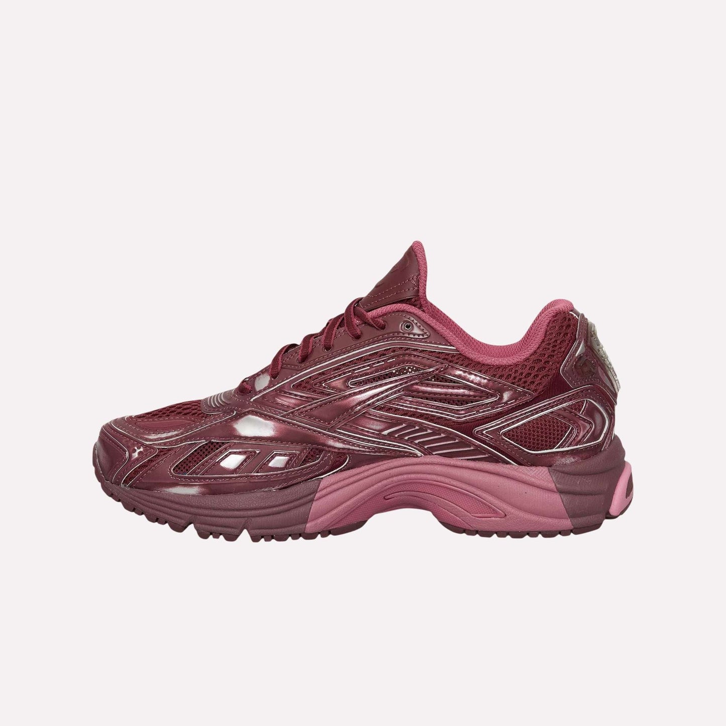 The Reebok Premier Road Ultra Shoes are maroon running sneakers with mesh and synthetic overlays, dark and light pink accents, a textured sole, and a low-top design for comfort, shown in left side profile on a white background.