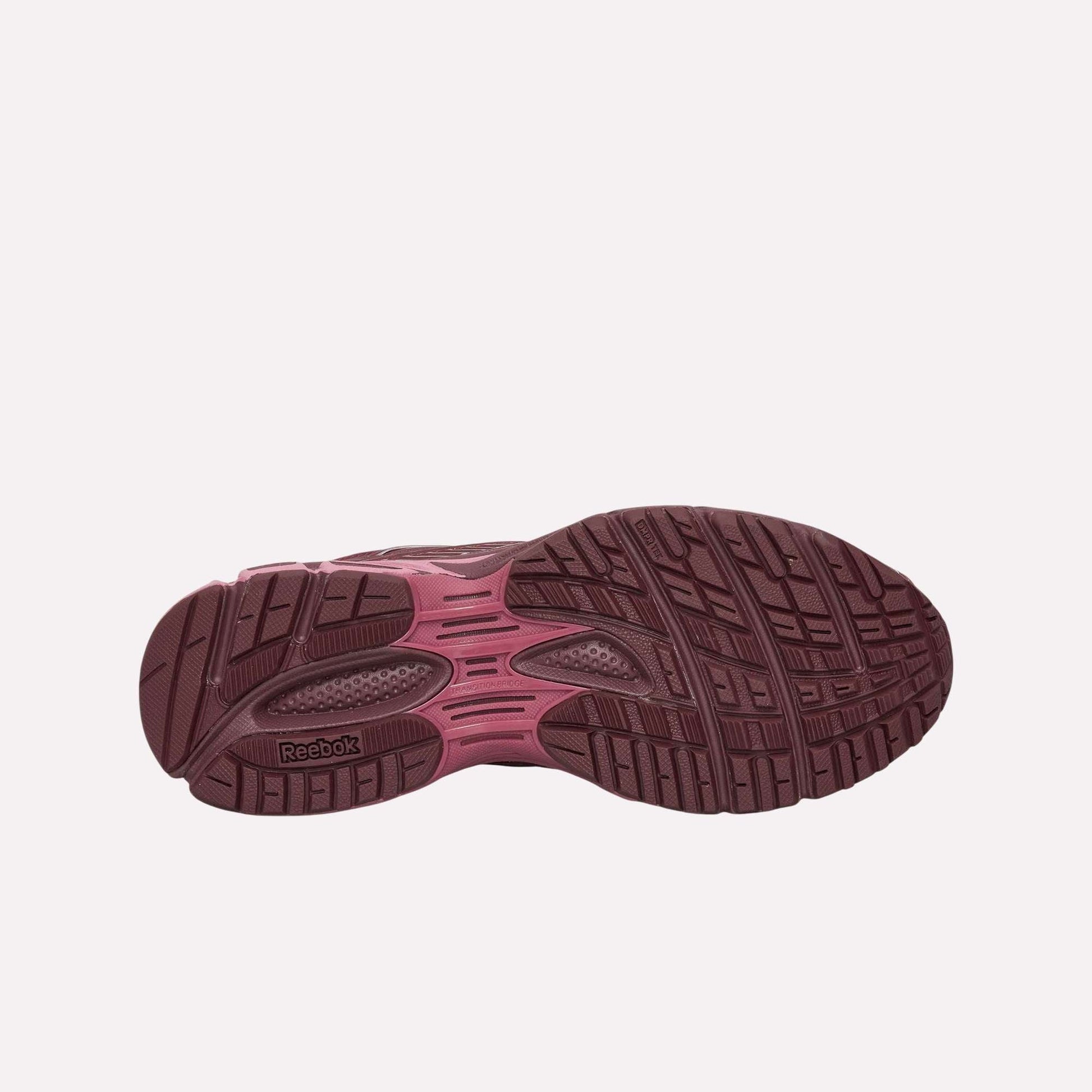 The image displays the bottom view of Reebok Premier Road Ultra Shoes, highlighting a maroon and pink treaded sole with textured grooves for comfort and stability, plus the Reebok logo near the heel.