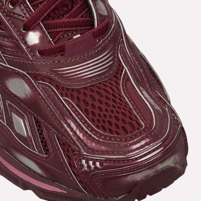 Close-up of the front of Reebok Premier Road Ultra Shoes, featuring maroon mesh and shiny synthetic overlays with detailed toe box stitching that emphasize comfort and stability.