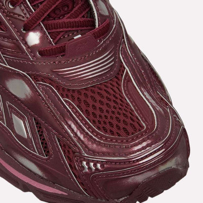 Close-up of the front of Reebok Premier Road Ultra Shoes, featuring maroon mesh and shiny synthetic overlays with detailed toe box stitching that emphasize comfort and stability.