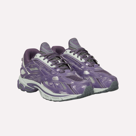 A pair of Reebok Premier Road Ultra Shoes in purple and gray with white laces, gray soles, a dual-density midsole, and a shiny finish is displayed on a plain white background.
