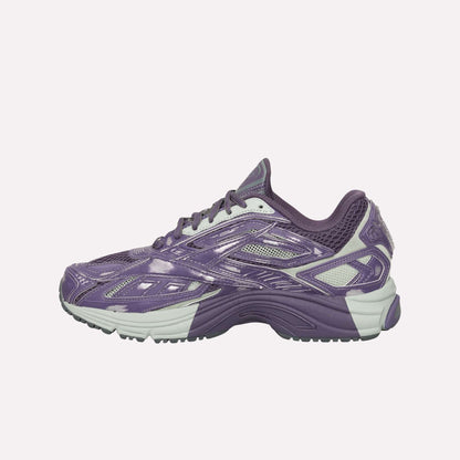 The Reebok Premier Road Ultra Shoes are shown in side profile on a white background, featuring purple and gray colors, a dual-density midsole, textured sole, and mesh details.